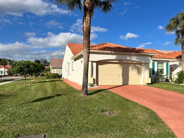 mediterranean / spanish-style home featuring a garage and a front yard