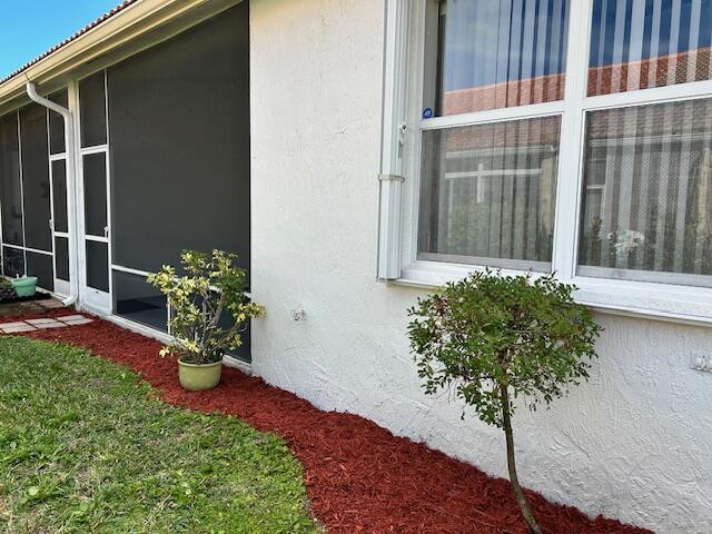 view of home's exterior with a yard and a sunroom