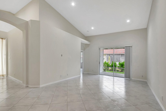 unfurnished room featuring light tile patterned floors and high vaulted ceiling