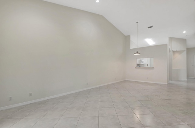 unfurnished room with lofted ceiling and light tile patterned floors