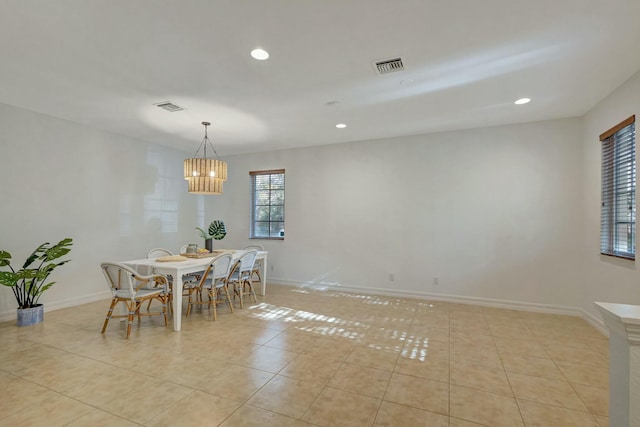 tiled dining area featuring a chandelier