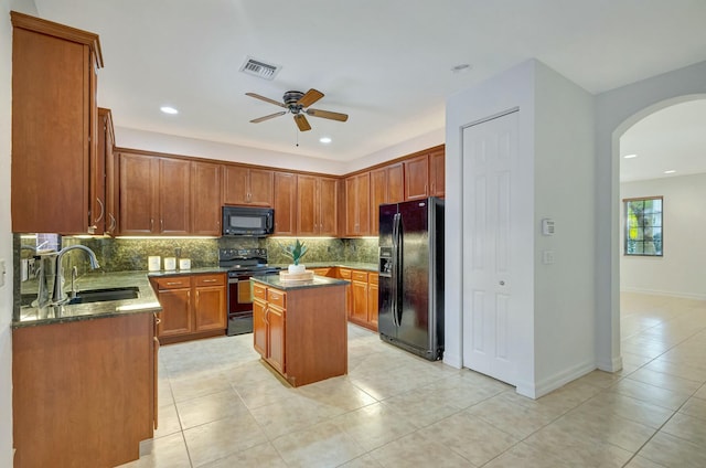 kitchen featuring sink, black appliances, a center island, and light tile patterned flooring