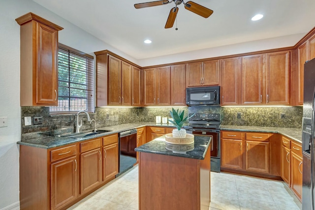 kitchen with dark stone countertops, sink, black appliances, and a center island