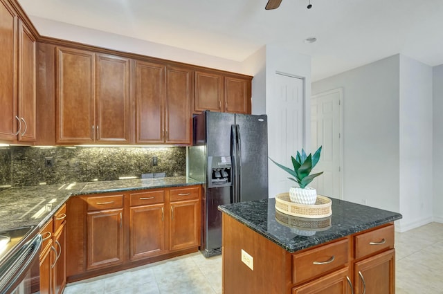 kitchen with black fridge with ice dispenser, tasteful backsplash, a center island, electric range, and dark stone countertops