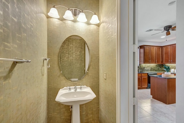 bathroom featuring ceiling fan, tile patterned floors, sink, and decorative backsplash