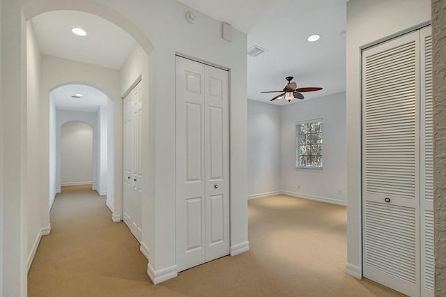 hallway featuring light colored carpet