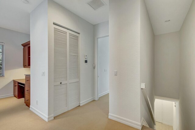 unfurnished bedroom featuring light carpet and a closet