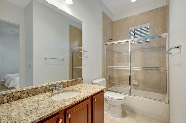 full bathroom with enclosed tub / shower combo, vanity, tile patterned floors, and toilet