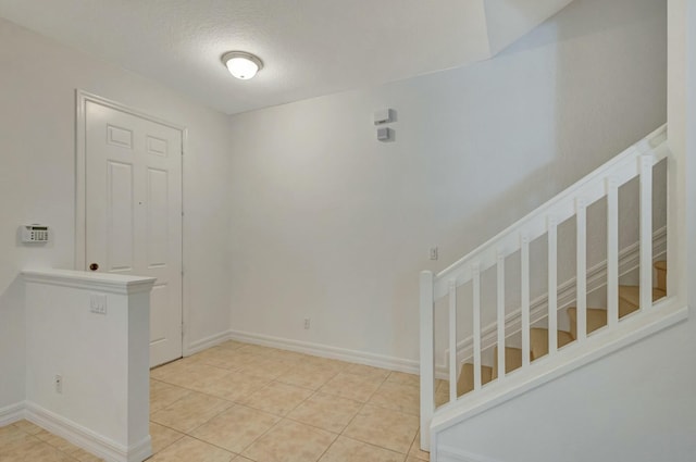 entryway with a textured ceiling and light tile patterned floors