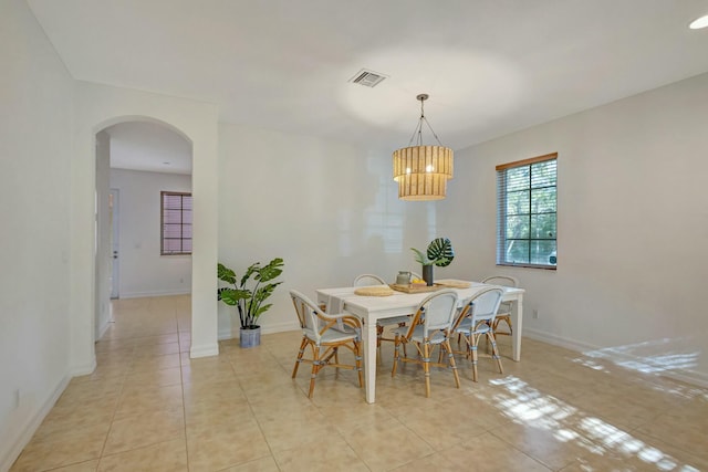 dining room with light tile patterned floors and an inviting chandelier