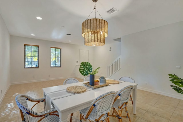 dining area featuring light tile patterned flooring and a notable chandelier