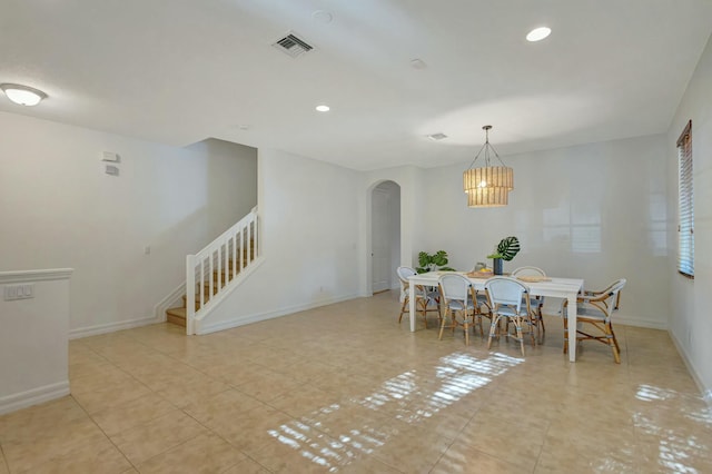 tiled dining space with an inviting chandelier