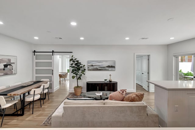 living room featuring light hardwood / wood-style flooring and a barn door