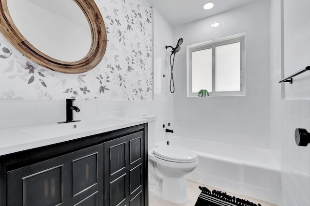 full bathroom featuring tiled shower / bath combo, vanity, and toilet