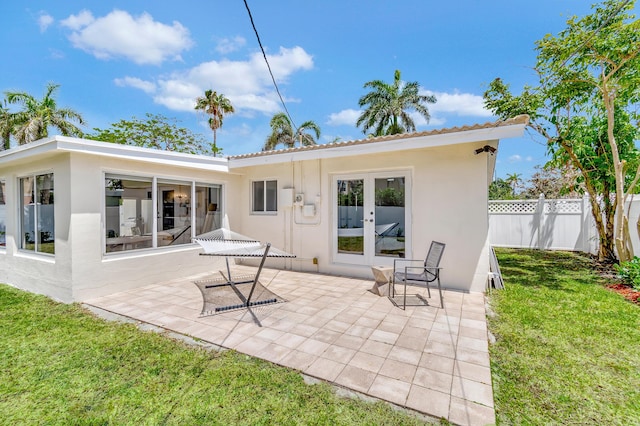 back of property with a yard and a patio