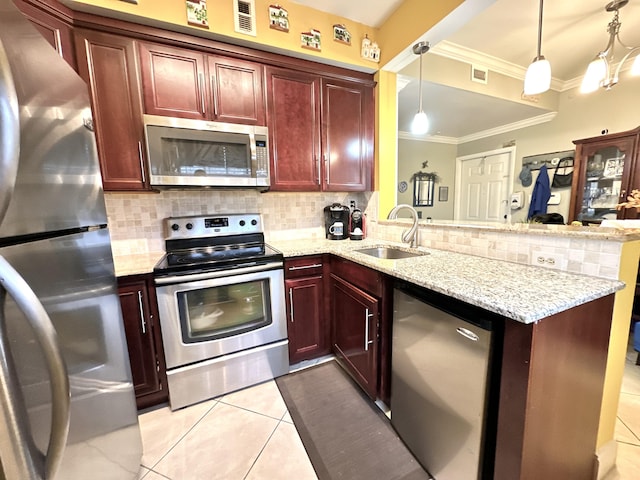 kitchen featuring stainless steel appliances, sink, decorative light fixtures, and kitchen peninsula