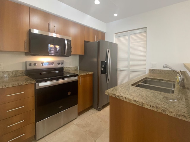 kitchen featuring sink, light tile patterned floors, stainless steel appliances, and light stone countertops