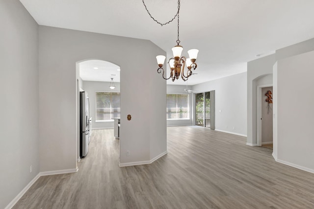 unfurnished dining area with a chandelier and light hardwood / wood-style floors