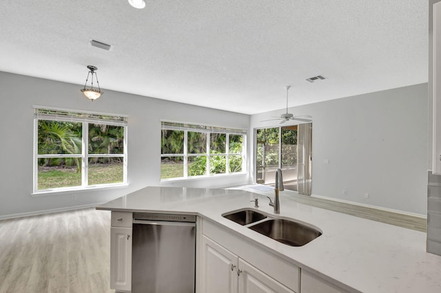 kitchen featuring pendant lighting, dishwasher, white cabinetry, sink, and plenty of natural light