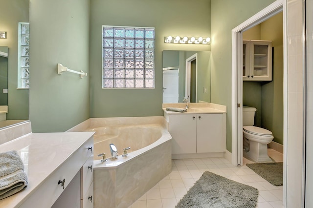 bathroom with tile patterned flooring, vanity, a tub, and toilet