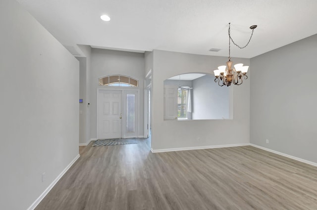 entrance foyer featuring hardwood / wood-style floors and a chandelier