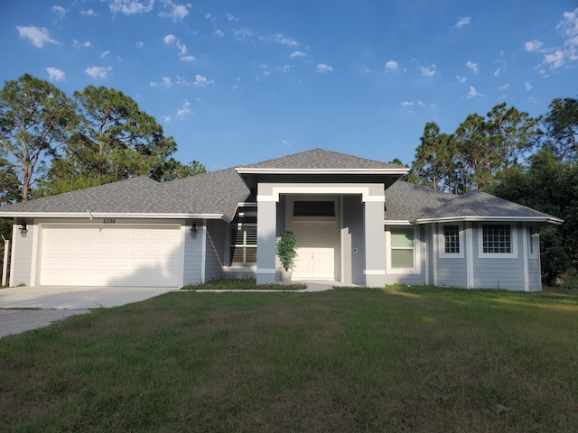 prairie-style house featuring a garage and a front lawn