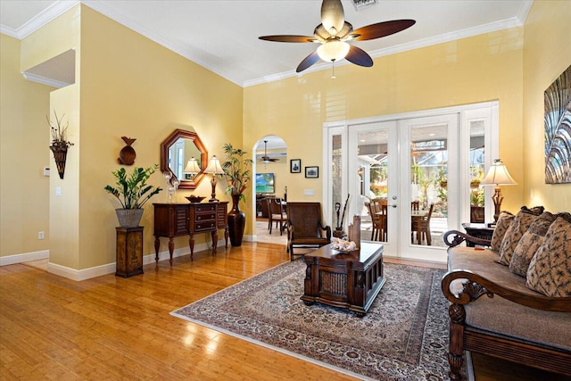 living room with hardwood / wood-style floors, ornamental molding, french doors, and ceiling fan