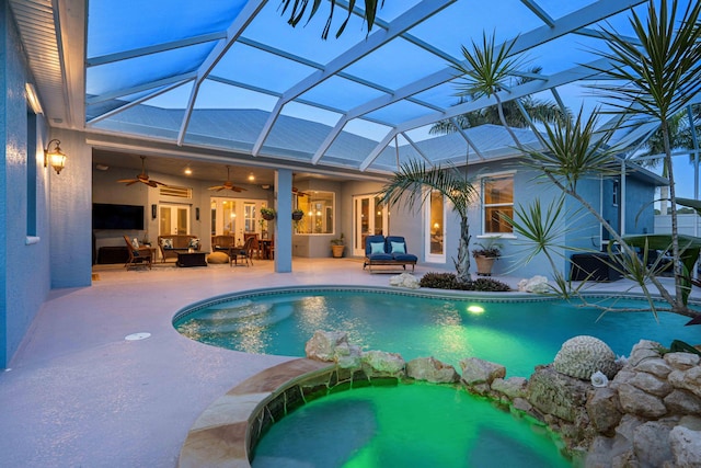 view of swimming pool featuring a ceiling fan, a pool with connected hot tub, outdoor lounge area, a lanai, and a patio area