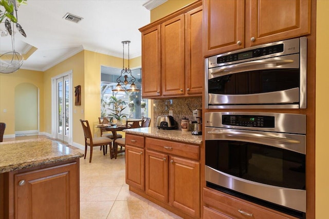 kitchen with light tile patterned flooring, double oven, decorative backsplash, crown molding, and light stone countertops