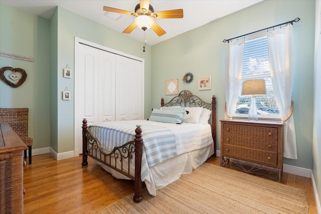 bedroom with ceiling fan, light hardwood / wood-style floors, and a closet