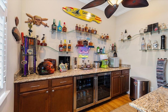 bar featuring a ceiling fan, wine cooler, light wood-style floors, a bar, and crown molding