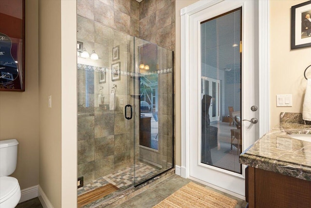 bathroom with vanity, toilet, a shower with shower door, and tile patterned flooring