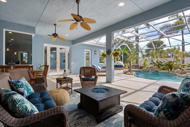 view of patio / terrace featuring a fenced in pool, an outdoor living space with a fire pit, a lanai, french doors, and a ceiling fan