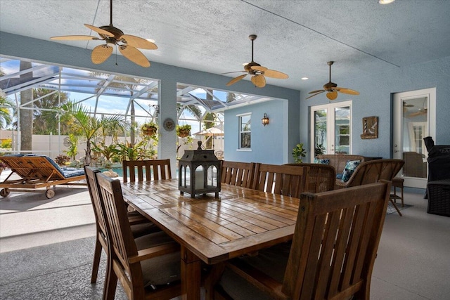 dining room featuring a wealth of natural light, a sunroom, and a textured ceiling