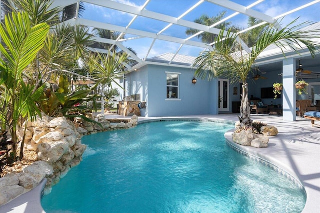 outdoor pool featuring a ceiling fan, a patio area, glass enclosure, and french doors