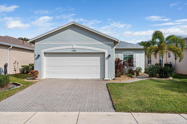 ranch-style house featuring a garage, a front yard, decorative driveway, and stucco siding