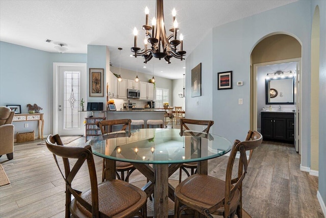 dining area featuring sink, a textured ceiling, and light hardwood / wood-style flooring