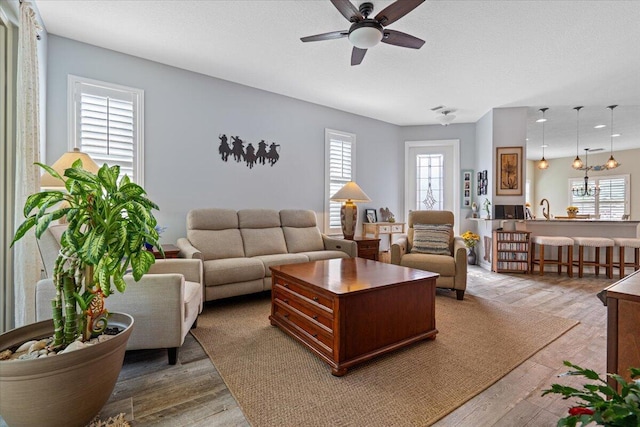 living room featuring sink, light hardwood / wood-style flooring, and ceiling fan