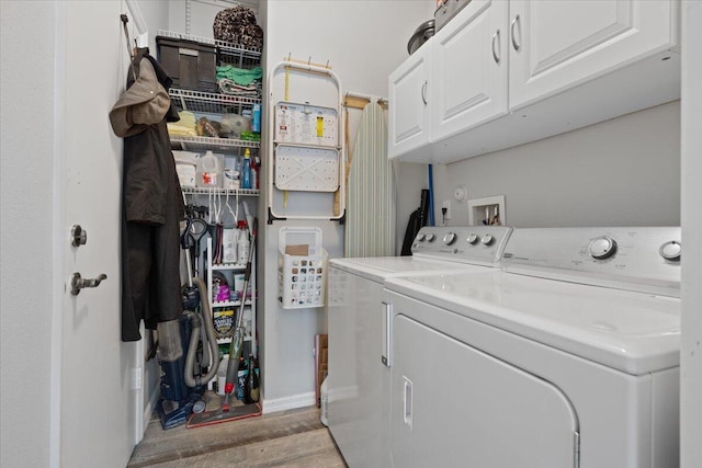 washroom with cabinets, washing machine and clothes dryer, and light wood-type flooring