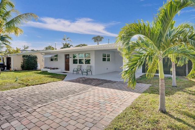 rear view of property featuring a lawn and a carport