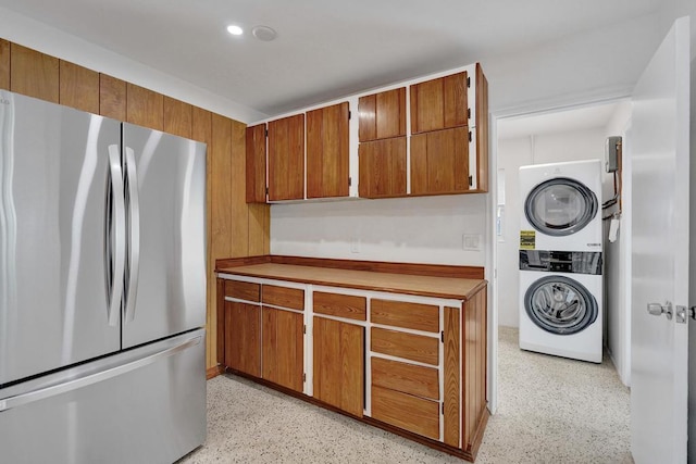 kitchen featuring stainless steel refrigerator and stacked washing maching and dryer