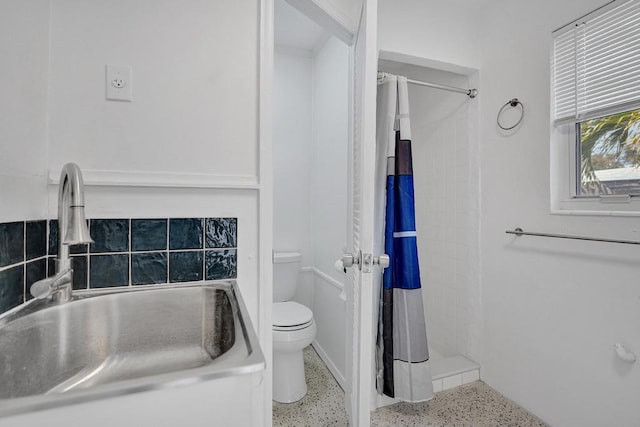 bathroom with toilet, curtained shower, and sink