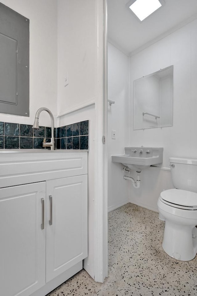 bathroom featuring toilet, electric panel, and sink