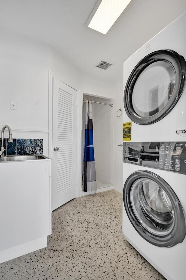 laundry area with sink and stacked washing maching and dryer