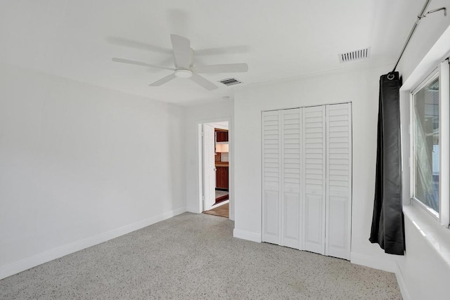 unfurnished bedroom with ceiling fan and a closet