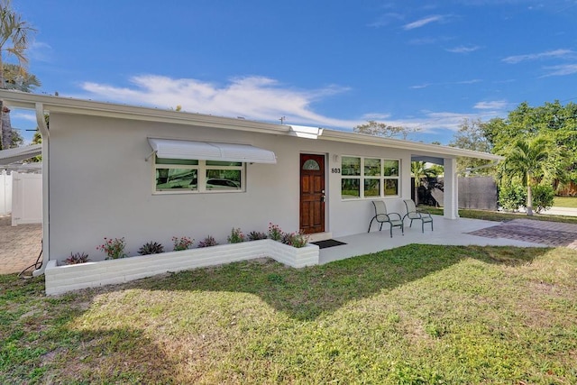 back of house with a yard and a patio