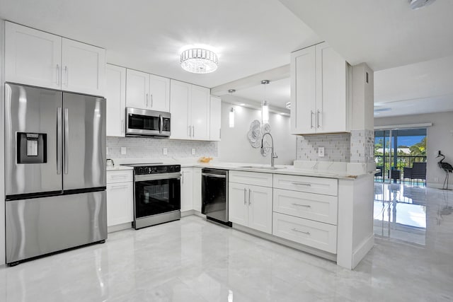 kitchen featuring appliances with stainless steel finishes, light stone countertops, white cabinets, pendant lighting, and kitchen peninsula