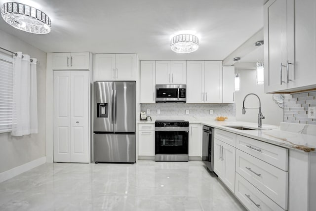 kitchen with stainless steel appliances, sink, light stone counters, white cabinets, and pendant lighting