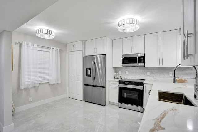 kitchen featuring white cabinetry, appliances with stainless steel finishes, and light stone counters