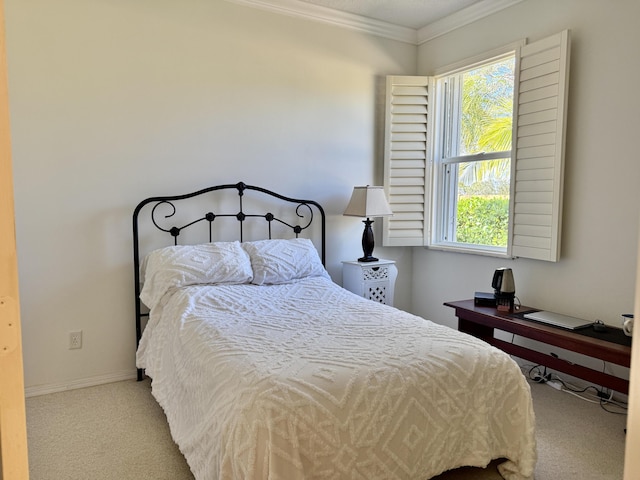 carpeted bedroom with ornamental molding and baseboards